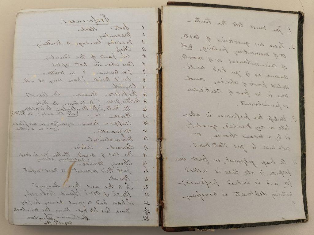 Color photograph of two pages of an open hardbound leather volume. The pages are blue and covered with handwriting in black ink. The left page contains four numbered paragraphs beginning with “1. You must tell the truth,” and the right page contains a list of 24 items under the heading “Preferences.” The binding of the volume is worn, stained, and separating from the spine.